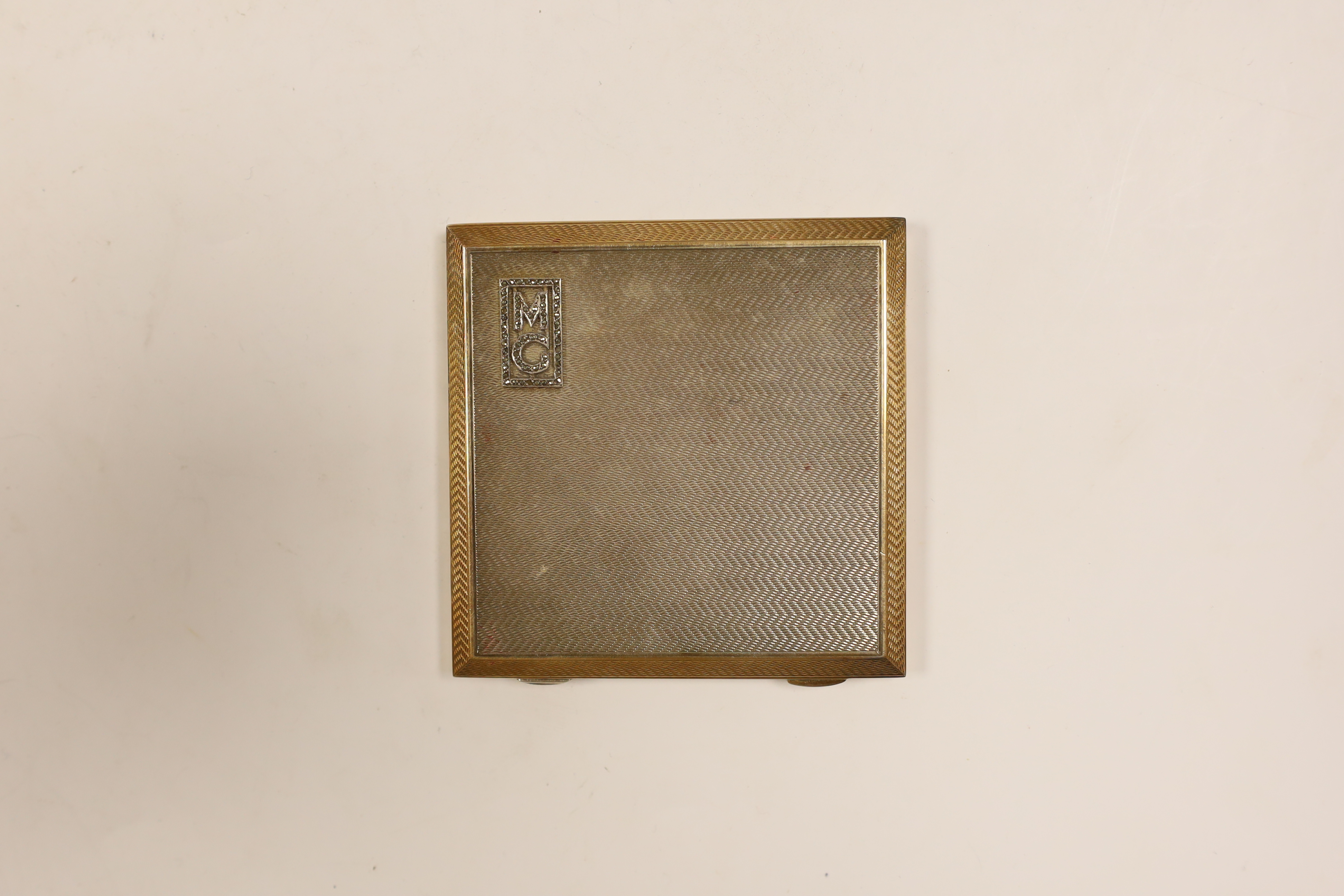 A George V engine turned silver and yellow metal compact, by Asprey & Co, with marcasite set initials 'MG', 72mm in original Asprey & Co fitted case (lacking powder puff).